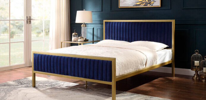 Bedroom with white metal double door on the left and blue velvet and golden metal framed bed against dark grey wall 